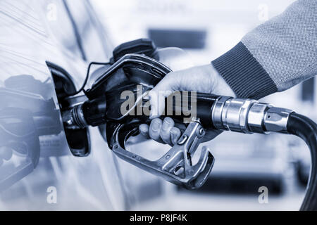 Nahaufnahme von mans hand Pumpen Benzin im Auto an der Tankstelle. Stockfoto