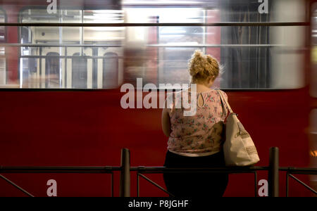 Belgrad, Serbien - Juli 2, 2018: Eine junge blonde Frau, die alleine stehen an der Bushaltestelle und warten auf den öffentlichen Transport in der Nacht und eine leere t Stockfoto