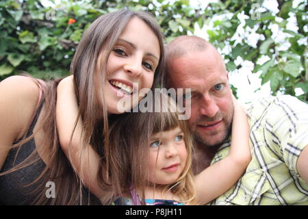 Schöne glückliche Familie kuscheln selfie Bild lange dunkle Haare Paar mit Kleinkind Stockfoto