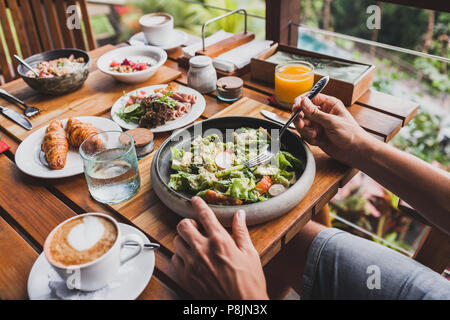 Blick von oben auf Tabelle mit frischem Frühstück. Man Hände, die Gabel und Messer Stockfoto