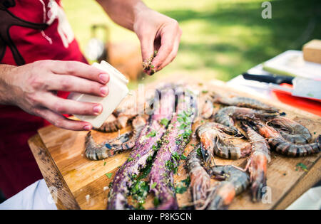 Nicht erkennbare Mann Vorbereitung Meeresfrüchte für einen Grill im Hof. Close Up. Stockfoto