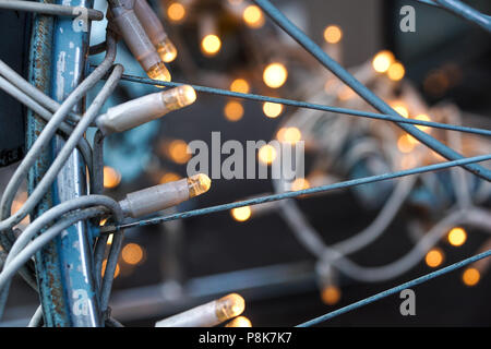 Traditionelle Weihnachtsbaumbeleuchtungen liegen auf einem Metall Fahrrad Stockfoto