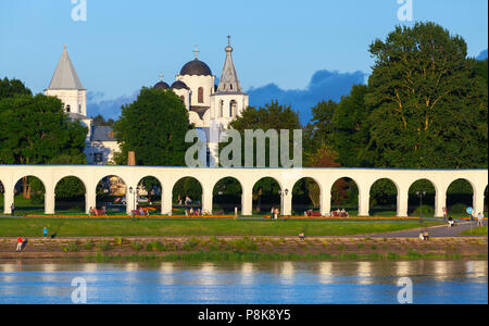 In Weliki Nowgorod, Russland - Juli 30, 2016: Landschaft mit Orthodoxen Kirchen unter blauen bewölkten Himmel im Sommer Abend. Gewöhnliche Menschen zu Fuß auf dem Fluss Küste Stockfoto