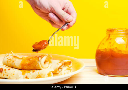 Traditionelle ukrainische oder russische Pfannkuchen. Fastnacht Maslenitsa. Traditionelle Gerichte auf den Urlaub Karneval Fastnacht Maslenitsa, von Hand mit einem Löffel Stockfoto