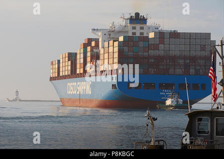 Stern angesichts der riesigen COSCO Container schiff, CSCL HERBST Auslaufen aus dem Hafen von Los Angeles, die Engel Tor Leuchtturm auf der linken Seite. Stockfoto