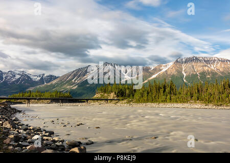 Abendsonne auf der Sommersonnenwende beleuchtet die Kennicott River, Wrangell Bergen und der Fußgängerbrücke zur McCarthy in Alaska. Stockfoto