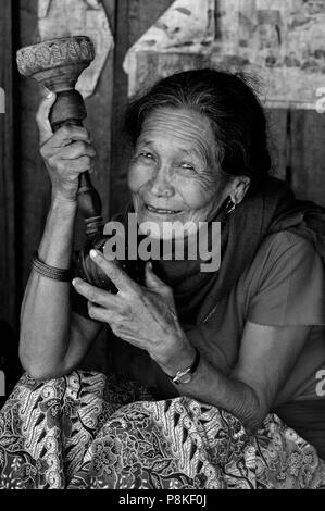 NEPALI Dorf Frau raucht Tabak in einer Shisha-Rohr - rund um MANASLU Trekking, NEPAL Stockfoto