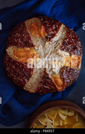 Cheddar Brezel Roggenbrot auf einer Indigo Bettwäsche Serviette und schwarzen Hintergrund Stockfoto