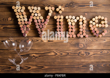 Wein Schriftzug von Korken mit zwei Gläsern gegen Holz- Hintergrund Stockfoto