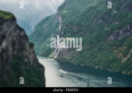 Geiranger, Norwegen 6/14/18 eine Kreuzfahrt Schiff fährt durch die Sieben Schwestern Wasserfälle in der Nähe von Geiranger, Norwegen. Geiranger ist das Tor zu den Fjorden Norwegens. Stockfoto