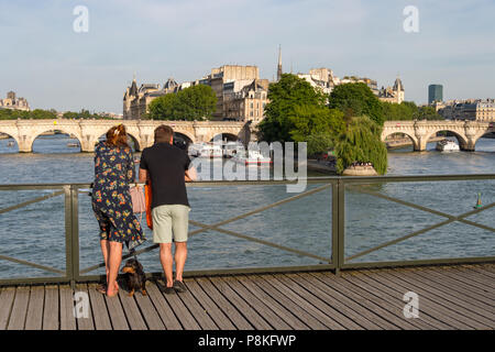 Paris, 24. Juni 2018: Touristen genießen den Blick von der Pont des Arts Brücke. Stockfoto