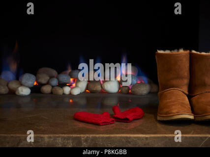 Stiefel und Handschuhe trocknen durch das Feuer. Stockfoto