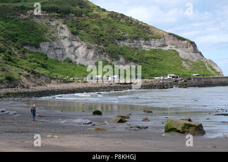 Die verräterische bis in die Hütten und Almen am alten Hafen von Port Mulgrave auf der Yorkshire Heritage Coast, England, UK, englische Flagge. Stockfoto