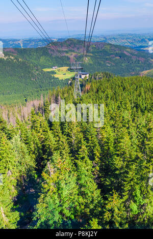 Eine Fahrt mit der Seilbahn über einem Wald in den Bergen, eine wunderschöne Landschaft Stockfoto