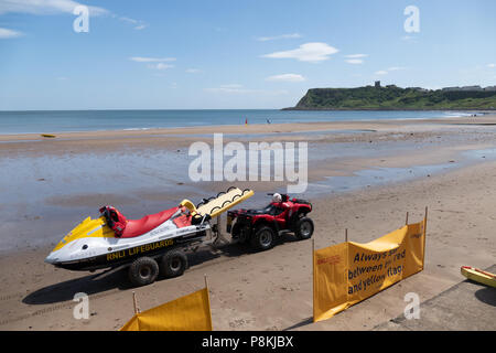 Rettungsschwimmer Rettungsfahrzeuge mit Strand Warnzeichen am Strand von North Bay, Scarborough, Großbritannien mit der Burg und Klippen in der Nähe geparkt. Stockfoto