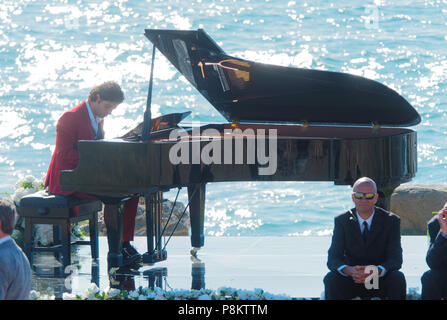 Newquay, Cornwall, England. 12. Juli 2018. Rosamunde Pilcher Schauspieler Manuel Mairhoffer spielt Klavier auf den Klippen, Filmen 'Meine Brüder Braut' Fistral Beach, UK, 12., Juli, 2018 Robert Taylor/Alamy Leben Nachrichten. Newquay, Cornwall, England. Credit: Robert Taylor/Alamy leben Nachrichten Stockfoto