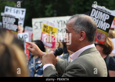 London, UK, 12. Juli 2018. Stoppt den Krieg Stuhl Murad Qureshi am Protest gegen Präsident des Trump Besuch in Großbritannien spricht. Demonstranten im Regents Park durch einen Zaun um den amerikanischen Botschafter Residenz gebaut für die Dauer des Trump Aufenthalt gesammelt. Roland Ravenhill/Alamy leben Nachrichten Stockfoto