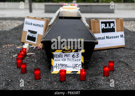 Berlin, Berlin, Deutschland. 12. Juli 2018. Ein Sarg, Geburtstagskuchen, Poster, Kerzen sind zu sehen auf dem Boden. Aktivisten protestieren vor dem Bundesministerium des Innern während der Gebetswache für die afghanischen Flüchtlinge Jamal Nasser die 23 M.-jährige sein eigenes Leben nach aus Deutschland nach Afghanistan abgeschoben zu werden. Der deutsche Bundesminister des Innern, Horst Seehofer machte Witze über diese besondere Deportation während der Präsentation des Masterplans Migration. Quelle: Markus Heine/SOPA Images/ZUMA Draht/Alamy leben Nachrichten Stockfoto