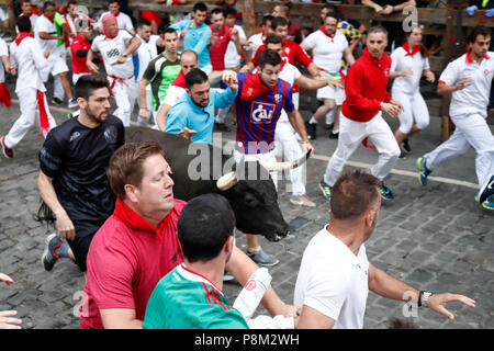 Pamplona, Spanien. 13. Juli 2018. Die Teilnehmer laufen neben Jandilla Kampfstiere auf der Vierten bullrun des San Fermin Festival in Pamplona, Spanien am 13. Juli 2018. 13. Juli 2018. Jeden Tag um 8 Uhr morgens Hunderte Leute rennen mit sechs Stiere, Ladung entlang einer Wicklung, 848.6 Meter (mehr als eine halbe Meile) Kurs durch die engen Straßen der Stierkampfarena der Stadt, wo die Tiere in einem Stierkampf oder Corrida getötet werden, während dieses Festivals zurück zu mittelalterlichen Zeiten und auch mit religiösen Prozessionen, Volkstanz, Konzerte und rund um die Uhr trinken. Credit: ZUMA Press, Inc./Alamy Stockfoto