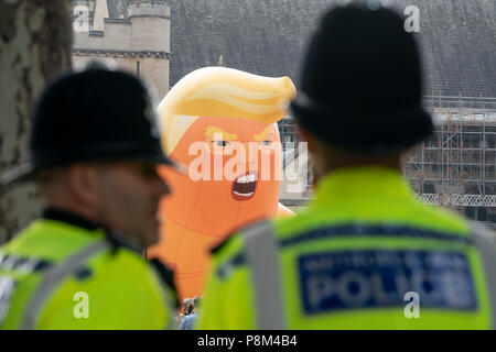 LONDON - Juli 13: Ein Donald Trump baby Ballon, fliegt über eine Gruppe von Polizisten in Parliament Square in London am 13. Juli 2018, während des Besuchs in Großbritannien durch US-Präsident, Donald Trump. Foto von David Levenson Credit: David Levenson/Alamy leben Nachrichten Stockfoto