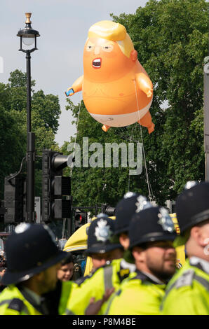 LONDON - Juli 13: Ein Donald Trump baby Ballon, fliegt über eine Gruppe von Polizisten in Parliament Square in London am 13. Juli 2018, während des Besuchs in Großbritannien durch US-Präsident, Donald Trump. Foto von David Levenson Credit: David Levenson/Alamy leben Nachrichten Stockfoto