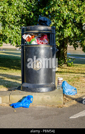 Volle Abfallbehälter überfüllt mit Müll auf und um ihn herum auf dem Boden, Nottinghamshire, England, Großbritannien Stockfoto