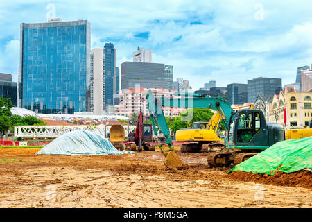 Bagger auf der Baustelle in Singapore Downtown, moderne Skyline im Hintergrund Stockfoto