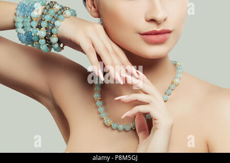 Schmuck auf weibliche Hand. Natürliche Farbe, Nägel, rosa Lippen und blau Armband Stockfoto