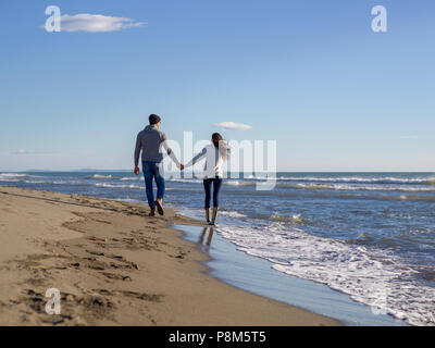 Junges Paar, das Spaß am Wandern und umarmen am Strand im Herbst sonniger Tag Stockfoto