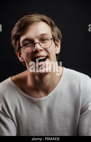 Nahaufnahme Foto des Blonden Kerl pretendingthat ist er auf etwas Lachen. lächelnd stunent in Gläser. Viel Spaß. Freude und Wonne Konzept Stockfoto