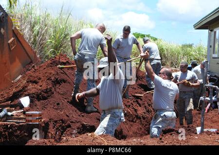 U.S. Air Force Airmen backfill an area over communication lines near homes being built at Helemano Plantation in Wahiawa, Hawaii, June 25, June 25, 2018. Georgia Air National Guardsmen from the 165th Airlift Wing in Savannah, Ga. and the 116th Air Control Wing at Robins Air Force Base, Ga. are contributing to the Aloha Garden Project, an initiative of the U.S. military's Innovative Readiness Training program. The program provides training and readiness for military personnel while addressing public and civil-society needs. (U.S. Air National Guard photo by Staff Sgt. Chelsea Smith). () Stockfoto