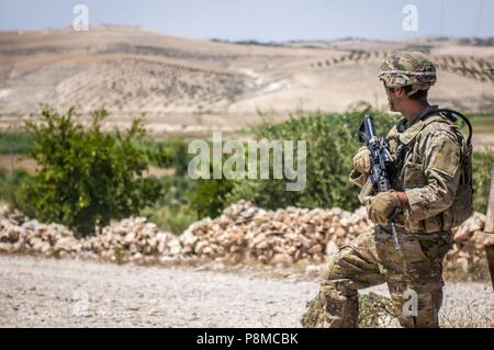 Ein US-Soldat liefert Sicherheit, während mit Blick auf die Abgrenzung in der Nähe von Manbij, Syrien, Juni 24, 2018, 24. Juni 2018. Türkische und US-Truppen patrouillieren auf jeder Seite der Linie, die Sicherheit und die Stabilität in der Region zu gewährleisten. (U.S. Armee Foto: Staff Sgt. Timothy R. Koster). () Stockfoto