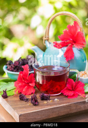 Rot karkade Hibiskus roter Sauerampfer Kaffee im Glas Becher mit trockenen Kaffee Vanillepudding aus roselle Blumen und Blüten auf einem Holz Stockfoto