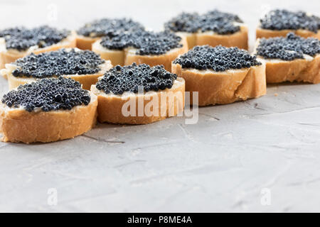 Teure leckere schwarze Kaviar Weißbrot sandwich Snack auf einem hölzernen Platte Stockfoto