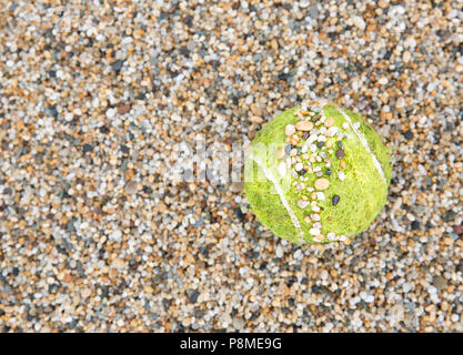 Ein Tennisball auf einem Kies Hof mit kleinen Steinen und Kies mit Kopie der Platz in einem Sport Hintergrund Stockfoto