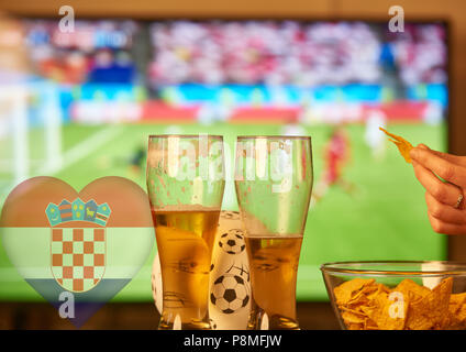 Double Exposure der kroatischen Flagge und zwei Gläser Bier vor dem Fernseher Fußball spielen Stockfoto