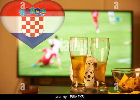 Double Exposure der kroatischen Flagge und zwei Gläser Bier vor dem Fernseher Fußball spielen Stockfoto