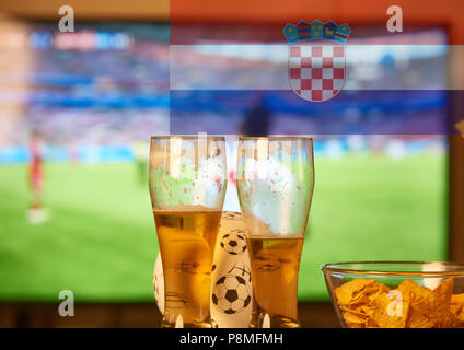 Double Exposure der kroatischen Flagge und zwei Gläser Bier vor dem Fernseher Fußball spielen Stockfoto