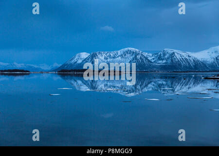 Die schneebedeckten Berge am See nach Sonnenuntergang widerspiegelt Stockfoto