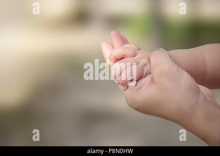 Die Mutter, die ihr Baby hand Close-up. Stockfoto