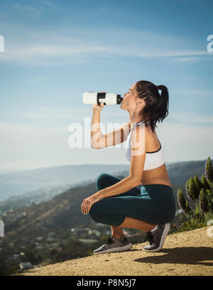 Frau in Sportbekleidung Trinkwasser aus der Flasche Stockfoto