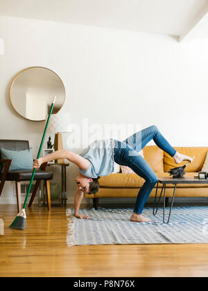 Frau, die sich nach hinten fegt und staubt Stockfoto