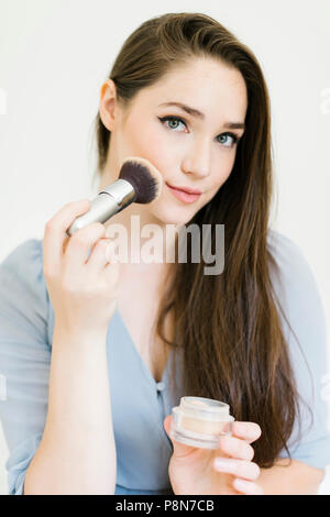Frau Anwendung Make-up mit Pinsel Stockfoto
