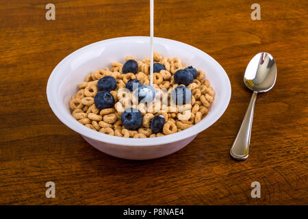 Eine Schüssel gerösteten Haferflocken Müsli in einer weißen Schüssel auf einen hölzernen Tisch Stockfoto