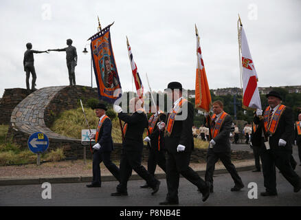 Eine Orange um Parade übergibt die "Hände über der Kluft" Statue in Londonderry als Teil der jährlichen Zwölften Juli feiern, Kennzeichnung der Sieg von König William III. Sieg über James II. in der Schlacht von Boyne im Jahre 1690. Bild Datum: Donnerstag, 12. Juli 2018. Siehe PA Geschichte ULSTER Paraden Londonderry. Photo Credit: Brian Gesetzlosen/PA-Kabel Stockfoto