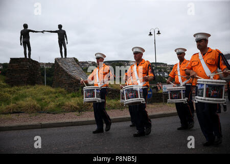 Eine Orange um Parade übergibt die "Hände über der Kluft" Statue in Londonderry als Teil der jährlichen Zwölften Juli feiern, Kennzeichnung der Sieg von König William III. Sieg über James II. in der Schlacht von Boyne im Jahre 1690. Bild Datum: Donnerstag, 12. Juli 2018. Siehe PA Geschichte ULSTER Paraden Londonderry. Photo Credit: Brian Gesetzlosen/PA-Kabel Stockfoto