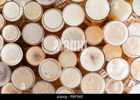 Eine Zusammenstellung der vollständigen, schaumiges Bier Gläser und Größen in einer Bar Bench Top. Stockfoto