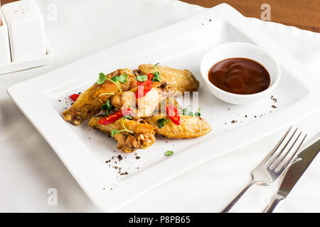 Gegrilltes gebackenes Huhn Flügel mit Chili und heiße Soße auf weiße Platte Stockfoto