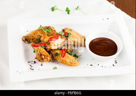 Gegrilltes gebackenes Huhn Flügel mit Chili und heiße Soße auf weiße Platte Stockfoto
