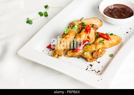 Gegrilltes gebackenes Huhn Flügel mit Chili und heiße Soße auf weiße Platte Stockfoto